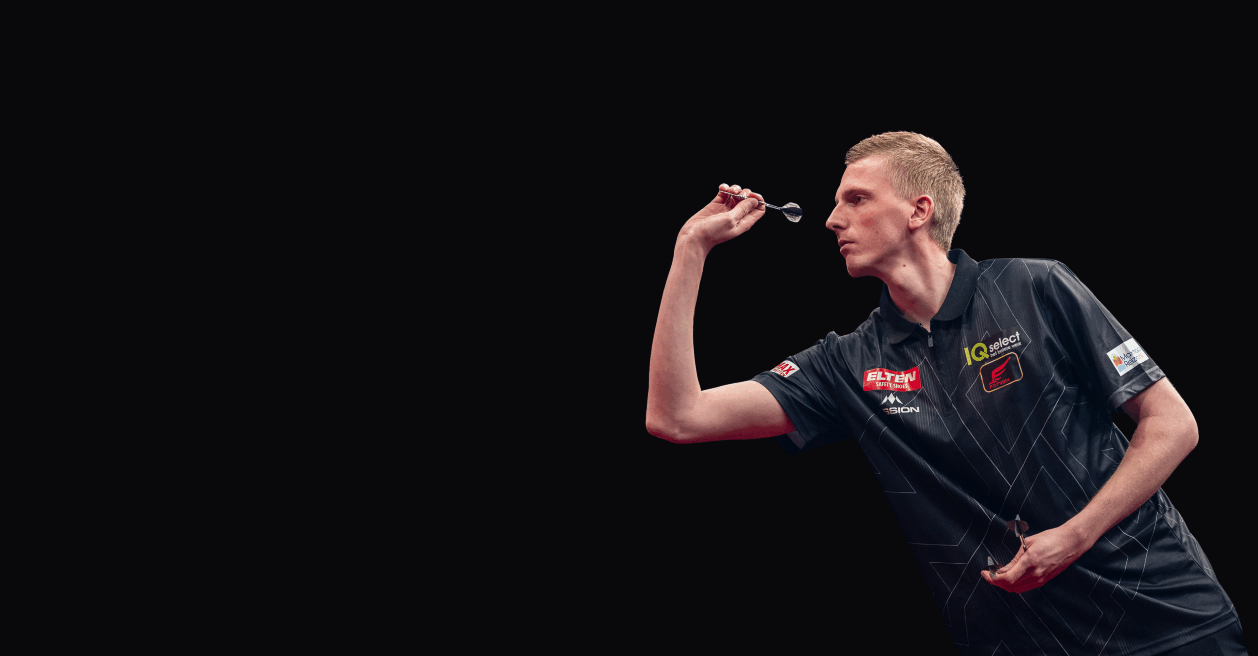 Nahaufnahme von Wessel Nijman während einer Aufnahme mit Dartpfeil in der rechten Hand und konzentriertem Blick nach vorne