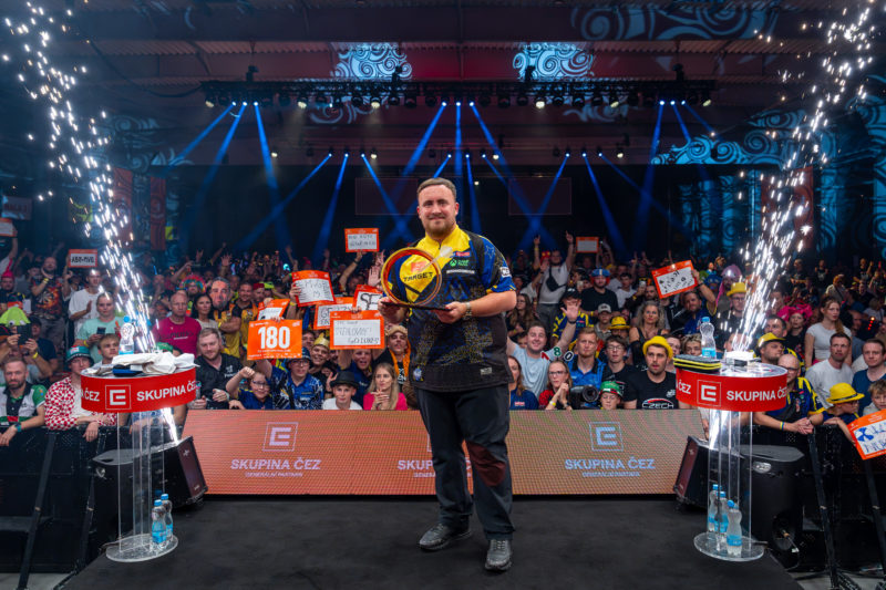 Luke Littler posiert als Sieger der Czech Darts Open 2026 mit Trophäe vor jubelndem Publikum in Prag